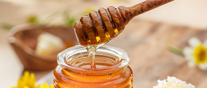 honey dipper being pulled out of a honey jar